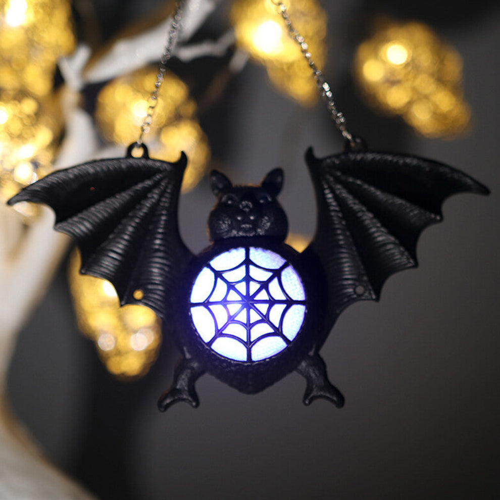 A 17x9cm black plastic bat LED light hanging lantern glowing against a dark spooky background.