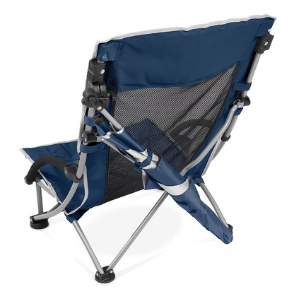 Low-profile blue folding Sport-Brella beach chair with breathable mesh back, padded armrest cup holder, and attached UPF 50+ shade umbrella set up on sunny ocean sand.