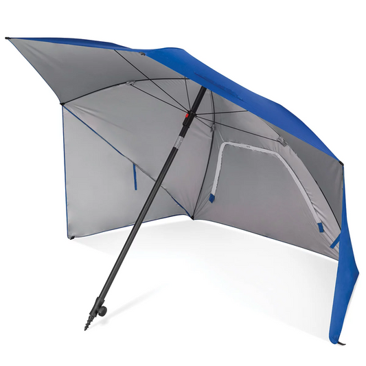 Large blue Sport-Brella Ultra 8 foot sun shelter with side privacy panels and built-in wind vents pitched on a sandy beach with lawn chairs underneath.