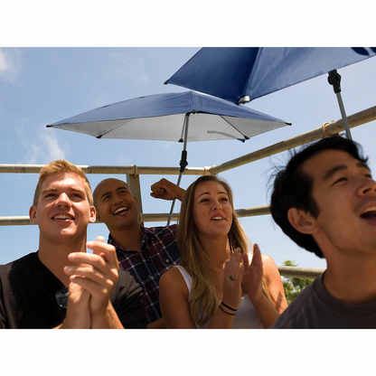 Compact blue Sport-Brella Versa-Brella personal umbrella with silver heat-reflective lining clamped securely to the armrest of an outdoor folding chair on a sunny day.