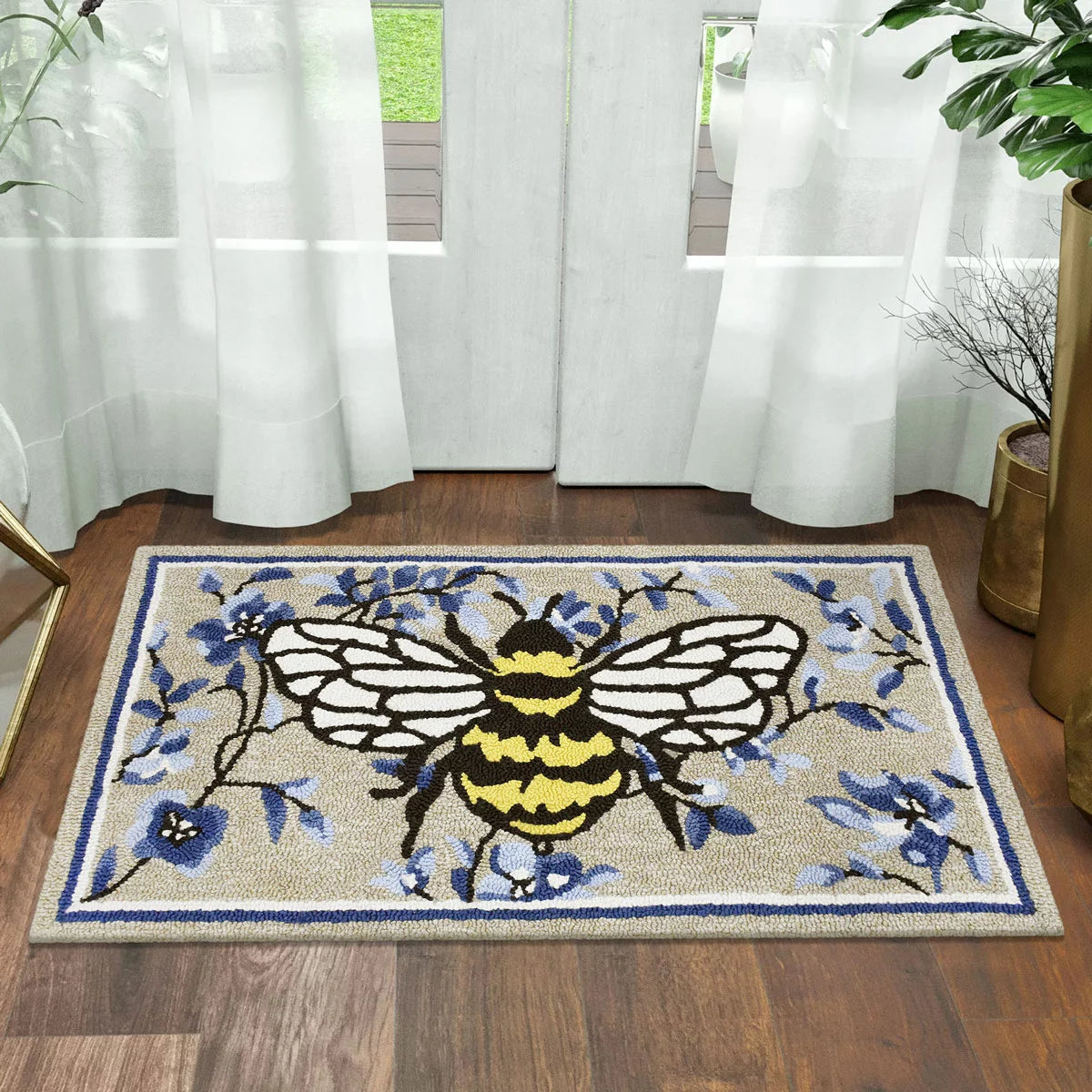 Top-down view of the colourful hand-hooked spring accent rug with textured floral motifs on a light hardwood entryway floor.