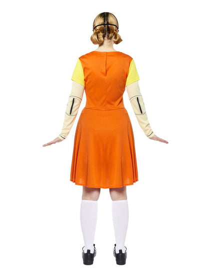 Adult wearing the orange pinafore dress and yellow collared shirt Squid Game doll costume standing in a full-length front view pose.