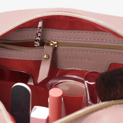 Stackers Heart Cosmetic Case in soft faux-leather, displayed next to a gold-accented mirror and beauty essentials on a clean white vanity surface.