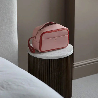Stackers Heart Cosmetic Case in soft faux-leather, displayed next to a gold-accented mirror and beauty essentials on a clean white vanity surface.