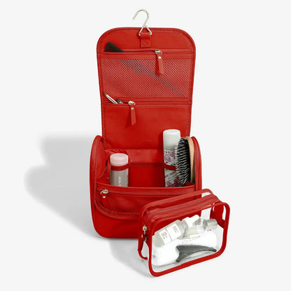 Stackers Large Hanging Washbag in red vegan leather, shown open to display its internal compartments, hanging hook, and the removable clear pouch.
