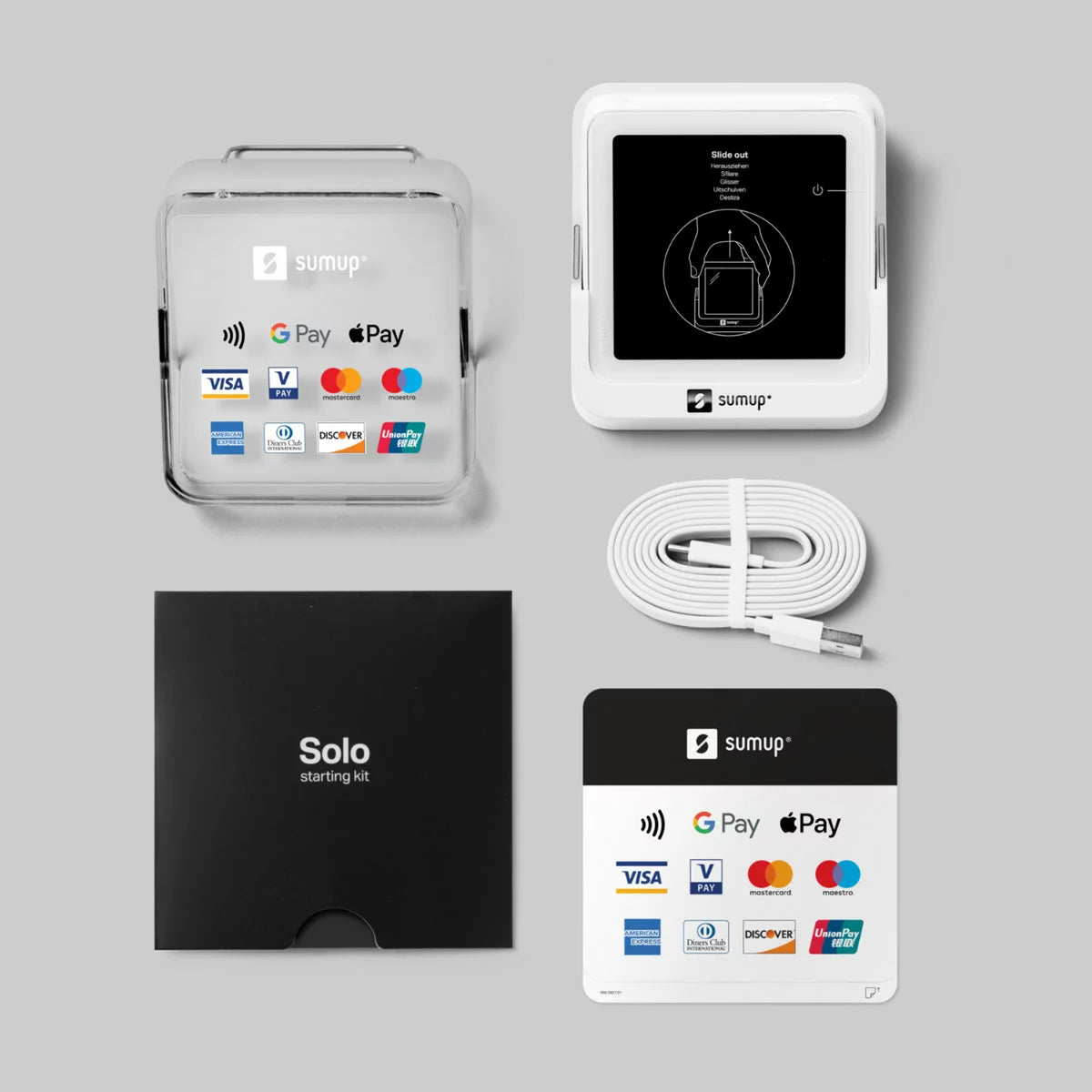 Compact white SumUp Solo touchscreen card reader resting on its angled countertop charging dock displaying a contactless payment prompt.