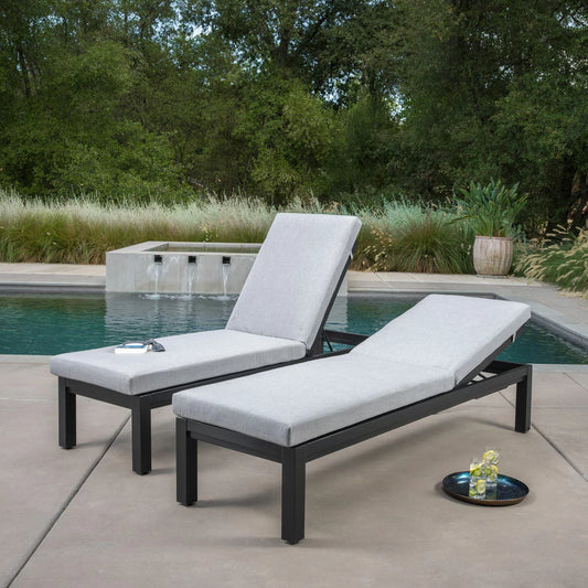 SunVilla Cinder Chaise Lounger set of two, featuring charcoal aluminium frames and plush Outdura cushions, positioned by a modern swimming pool.