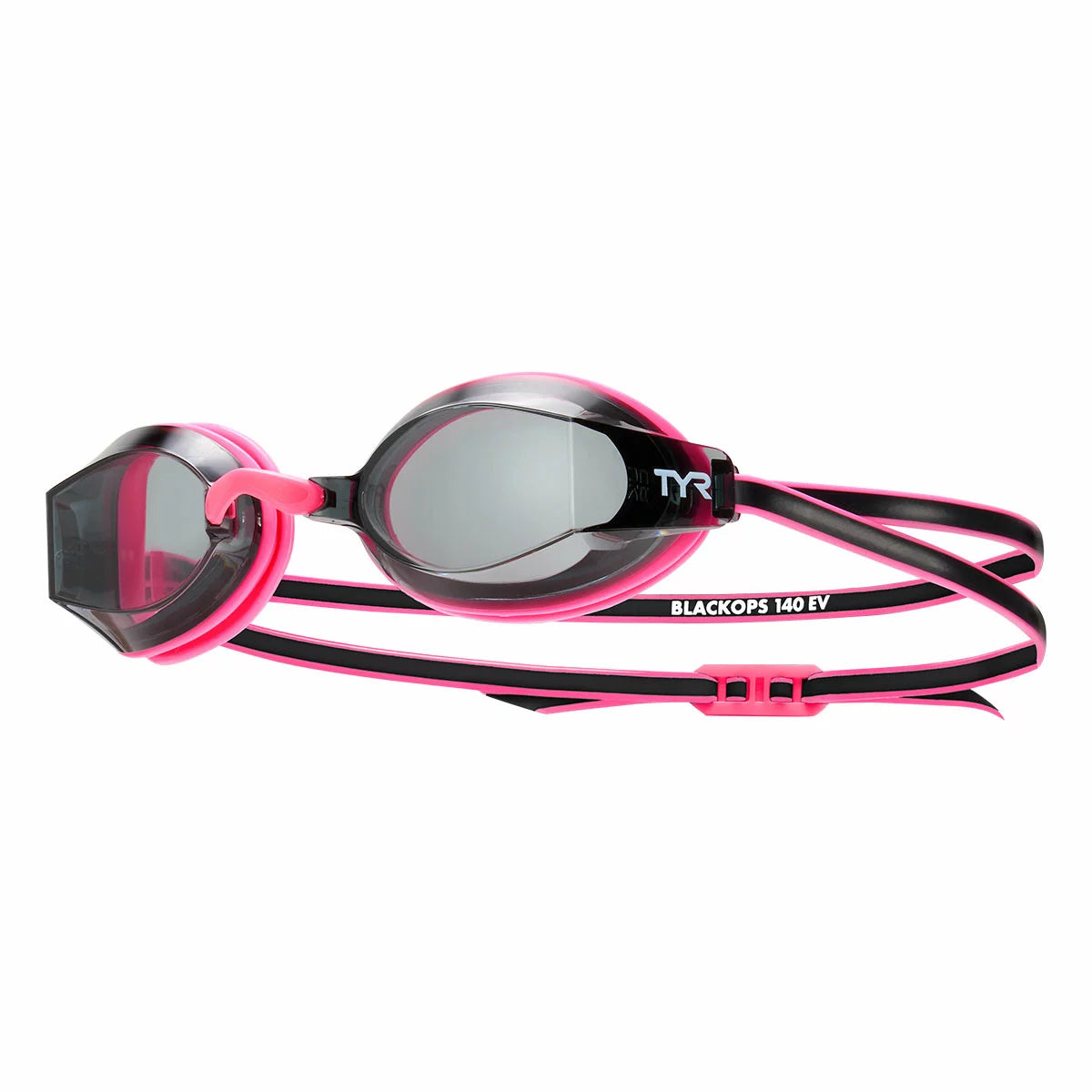 Three pairs of low-profile TYR junior swimming goggles in blue, pink, and clear silicone frames resting on a damp pool bench, showing the anti-fog coated polycarbonate lenses.