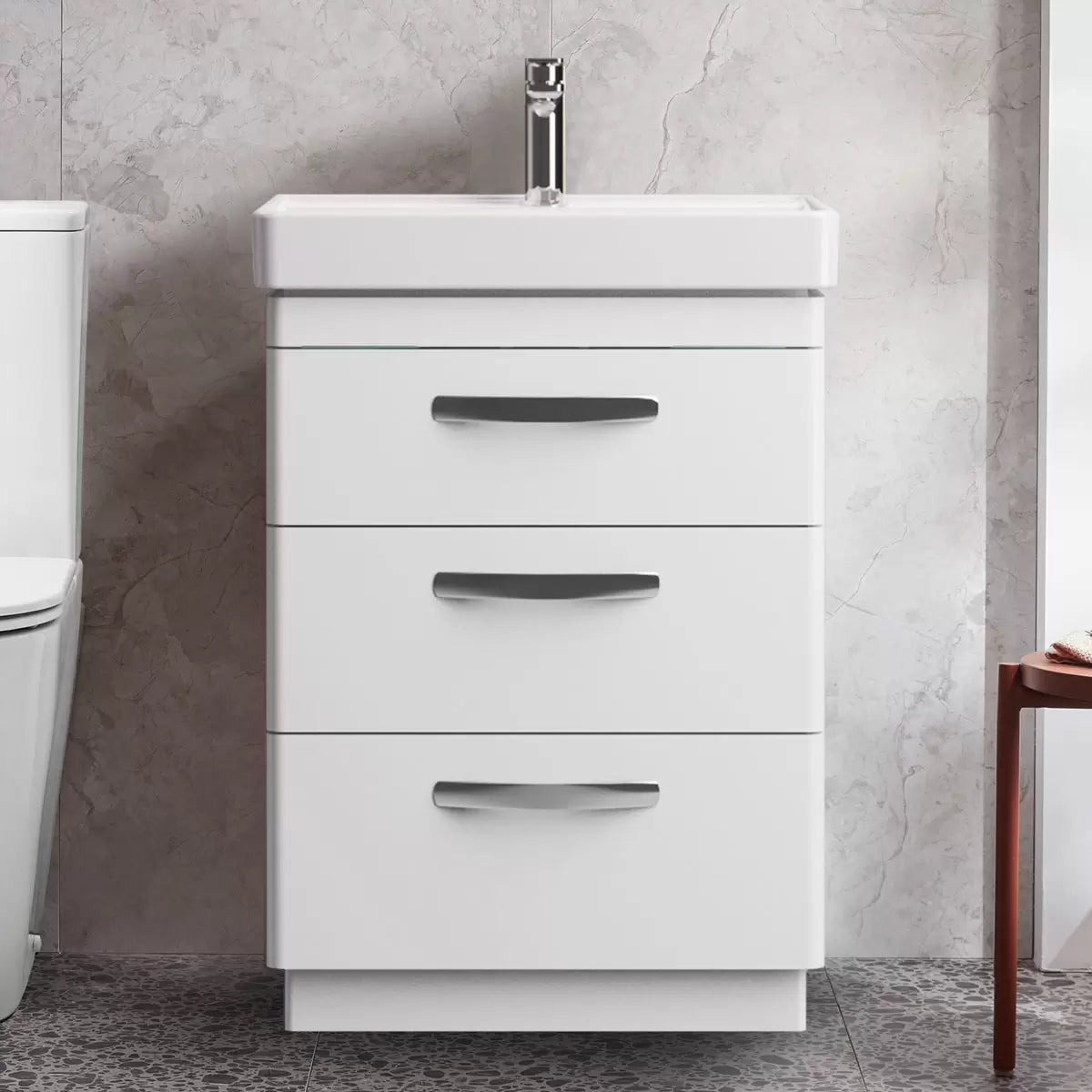 Front angle view of the Tavistock Curve 60cm floor mounted vanity unit featuring three smooth soft-close drawers with curved chrome handles and a deep white ceramic basin integrated into a modern bathroom setting.