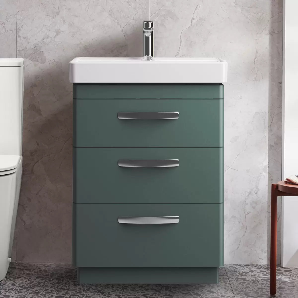Front angle view of the Tavistock Curve 60cm floor mounted vanity unit featuring three smooth soft-close drawers with curved chrome handles and a deep white ceramic basin integrated into a modern bathroom setting.