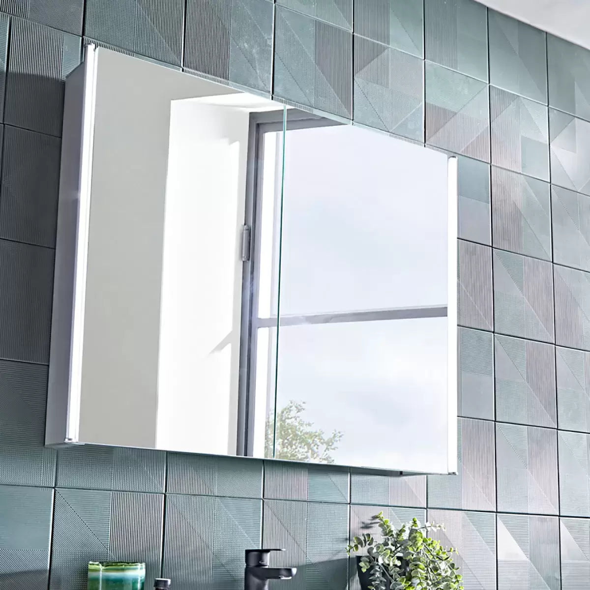 Front angle view of the silver Tavistock Endure 2 Door Mirror Cabinet mounted on a slate grey tiled bathroom wall, illuminated by its integrated side LED strip lights reflecting a bright modern vanity setup