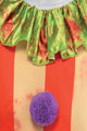 Full-length front view of a teenager wearing a sinister distressed clown costume with a ruffled collar inside a dimly lit haunted hallway.