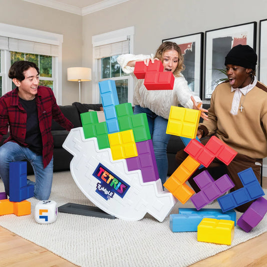 Giant 6ft wooden Tetris XL tumble tower standing tall on a green lawn during a sunny outdoor party.
