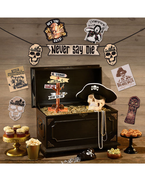 The Goonies room decorating kit featuring a 3.6m party banner, 28.1cm centerpiece, and multi-sized film cutouts arranged on a dark background.