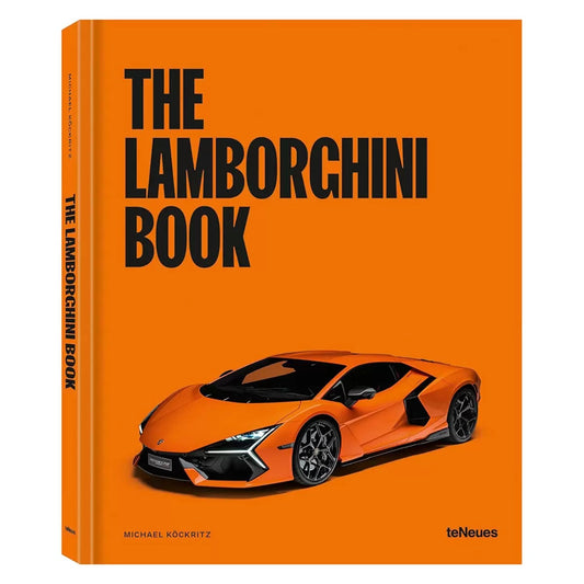 Large hardback coffee-table volume of The Lamborghini Book by Michael Köckritz displayed open to reveal a vibrant full-page photograph of an Italian supercar.
