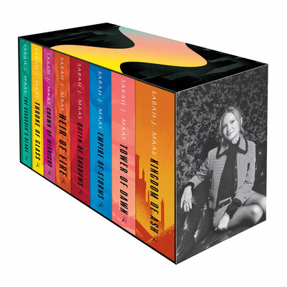 Three-quarter angle shot of the Throne of Glass eight-book paperback box set by Sarah J. Maas, showing the black illustrated slipcase and the vibrant, multicoloured book spines aligned inside.