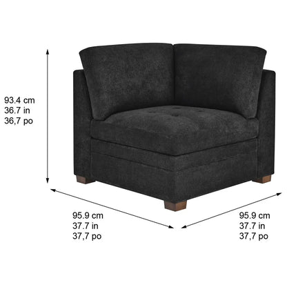 Front angled view of the Thomasville Tisdale dark grey fabric corner chair featuring tufted seat cushions and solid block wood legs on a modern light oak floor.