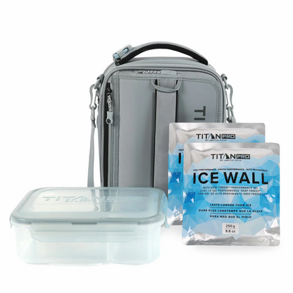 Three-quarter view of the expandable blue Titan Pro Lunch Box in its expanded state on a stone kitchen island, with the bento box and ice walls placed neatly beside it.