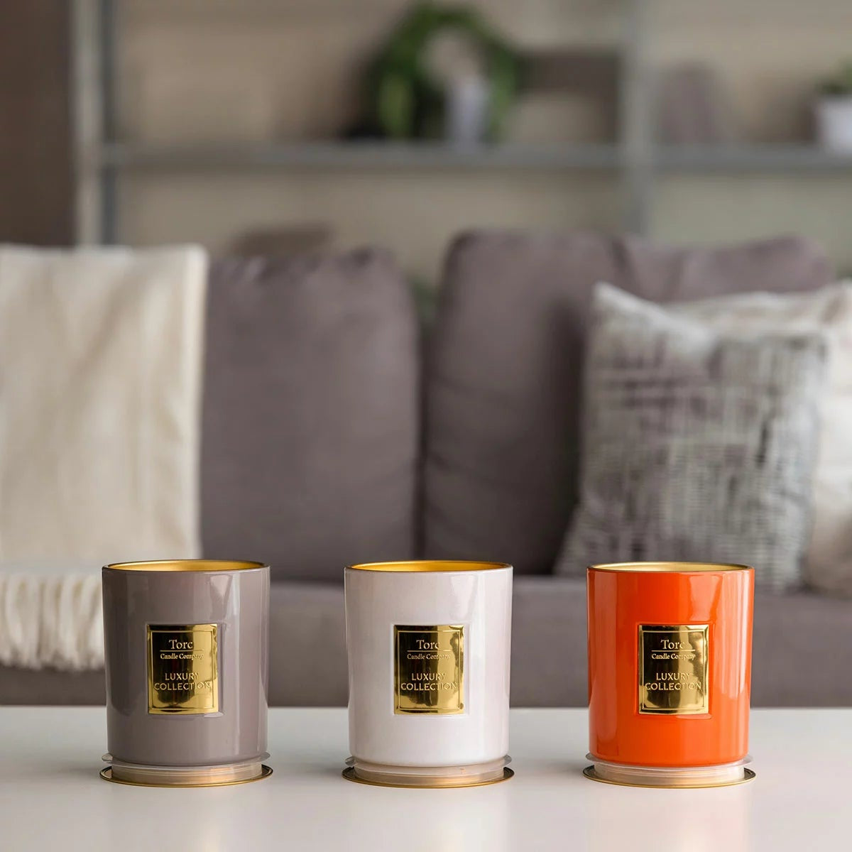 Three clear glass Torc scented candles with wooden lids arranged on a rustic wooden table displaying rich wax textures inside.