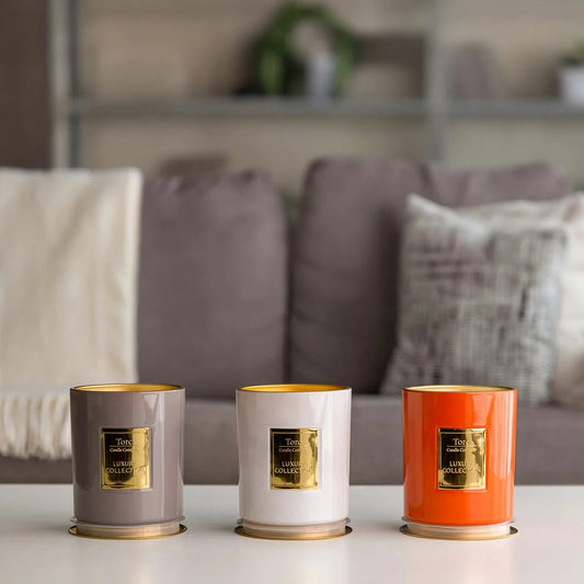 Three clear glass Torc scented candles with wooden lids arranged on a rustic wooden table displaying rich wax textures inside.