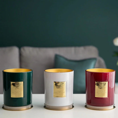Three clear glass Torc scented candles with wooden lids arranged on a rustic wooden table displaying rich wax textures inside.