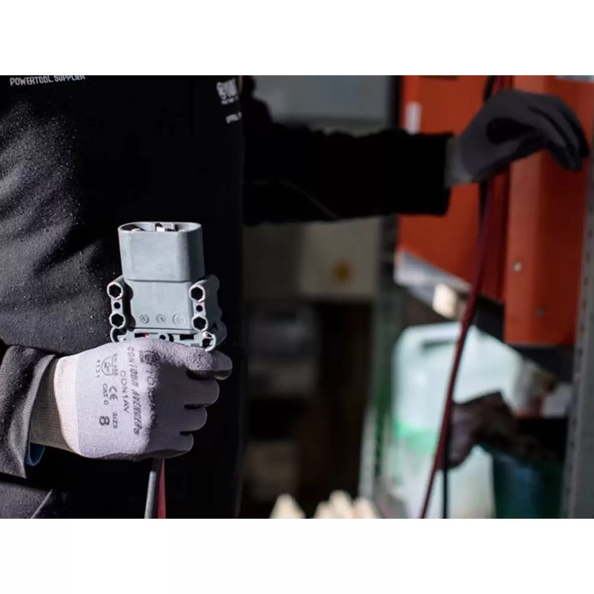 Black and grey Tornado Contour Avenger seamless nylon work gloves with bi-polymer palm coating on a technician workbench.
