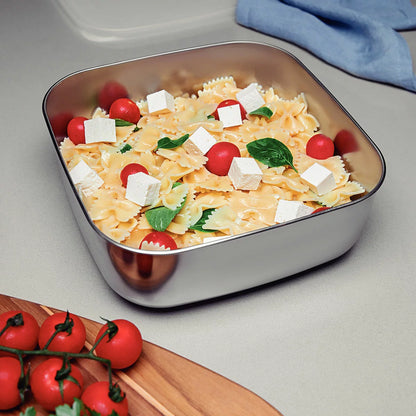 Tramontina 3-piece stainless steel food storage container set with airtight lids on a kitchen counter.