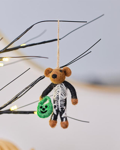 Trick or Treat Skeleton Tree Decoration featuring a bone-white sculpted resin skeleton hanging on a dark autumn branch.