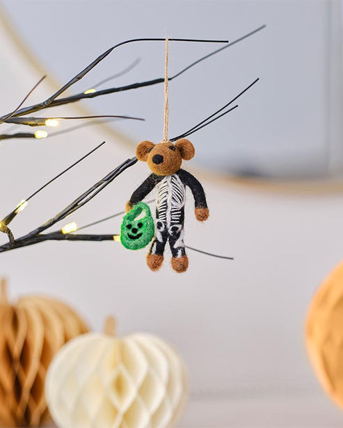 Trick or Treat Skeleton Tree Decoration featuring a bone-white sculpted resin skeleton hanging on a dark autumn branch.
