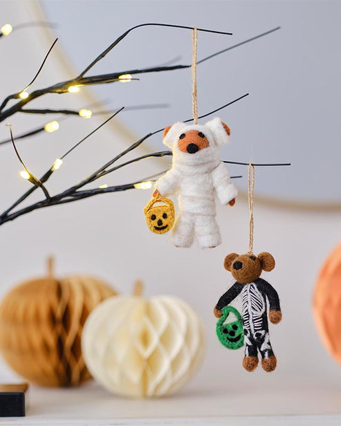 Trick or Treat Skeleton Tree Decoration featuring a bone-white sculpted resin skeleton hanging on a dark autumn branch.