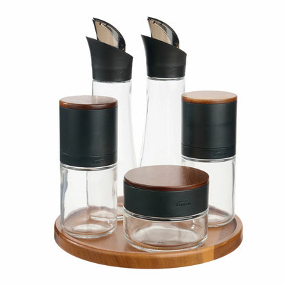 Trudeau 6-piece seasoning station featuring salt and pepper mills, oil bottles, and a rotating acacia base.