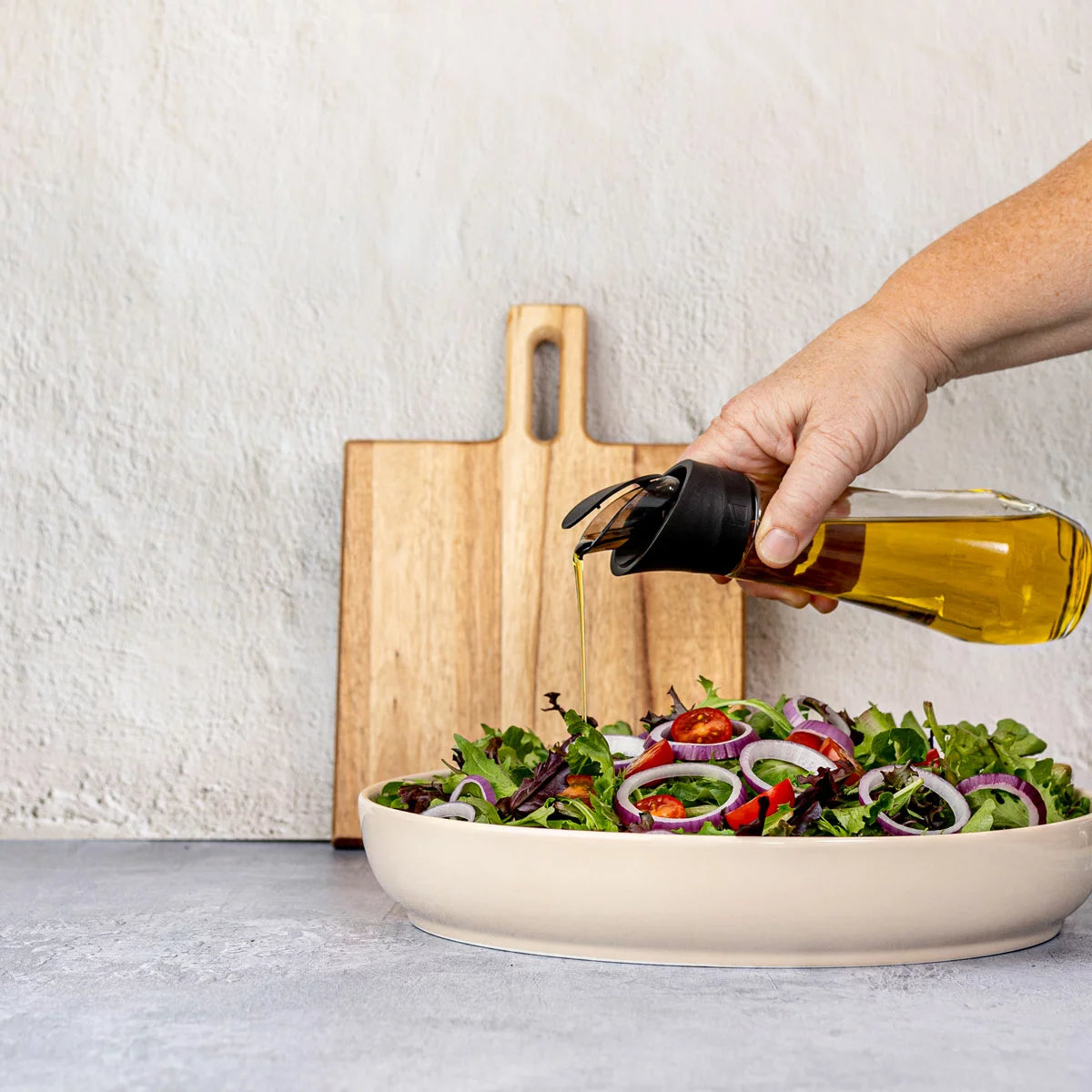 Trudeau 6-piece seasoning station featuring salt and pepper mills, oil bottles, and a rotating acacia base.