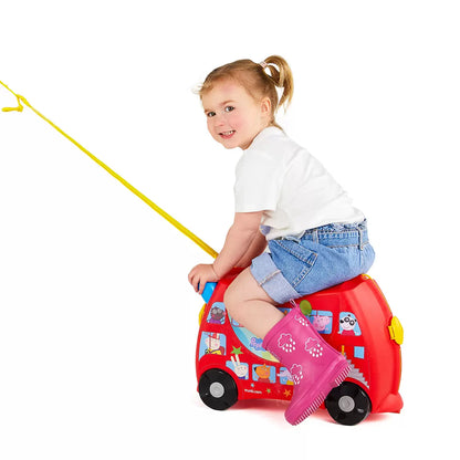 The Trunki Peppa Pig Party Bus ride-on suitcase in bright red with Peppa Pig branding, displayed on a clean studio floor to show its wheels and steering horns.