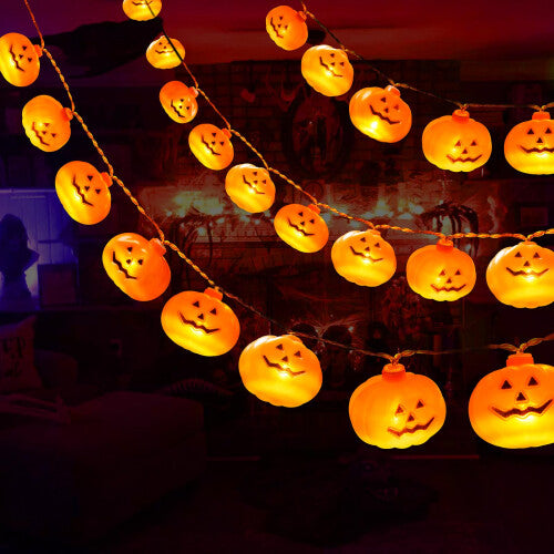 A 5-meter strand of 30 LED 3D pumpkin string lights glowing warmly along an outdoor wooden garden fence.