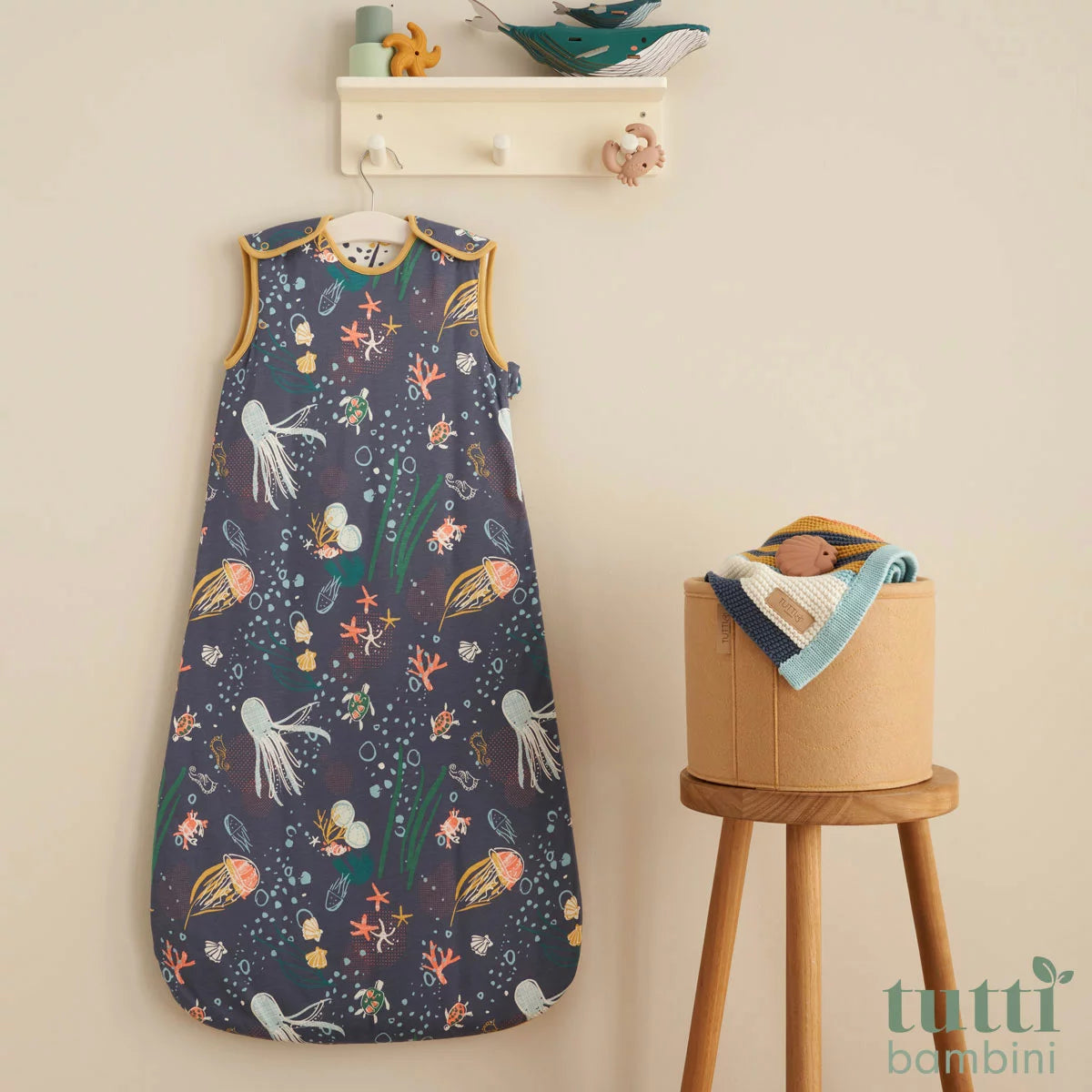 Tutti Bambini white and blue 2.5 Tog bamboo cotton baby sleeping bag displayed flat on a neutral nursery surface.