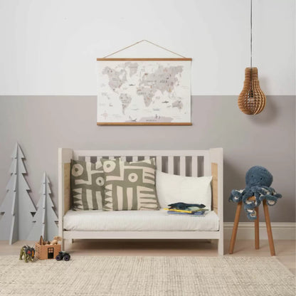 Three-quarter studio shot of the built white sand and distressed oak Tutti Bambini Alba Mini Cot Bed containing its fabric mattress.