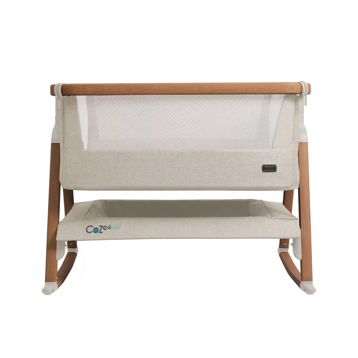 Tutti Bambini CoZee Air Bedside Rocking Crib in Walnut frame and Ecru fabric set up beside a adult bed with mesh side lowered.