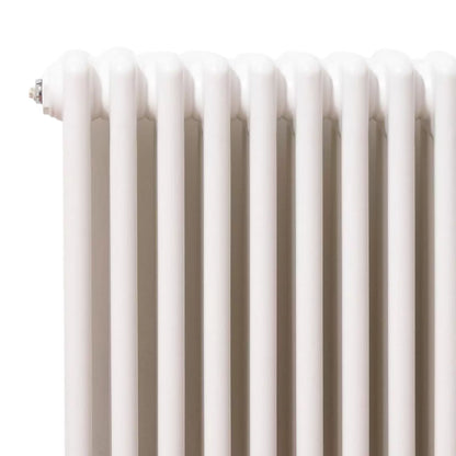 Vertical white 3-column steel radiator, 1800x465mm size, mounted on a light interior wall highlighting ten triple-tube sections.