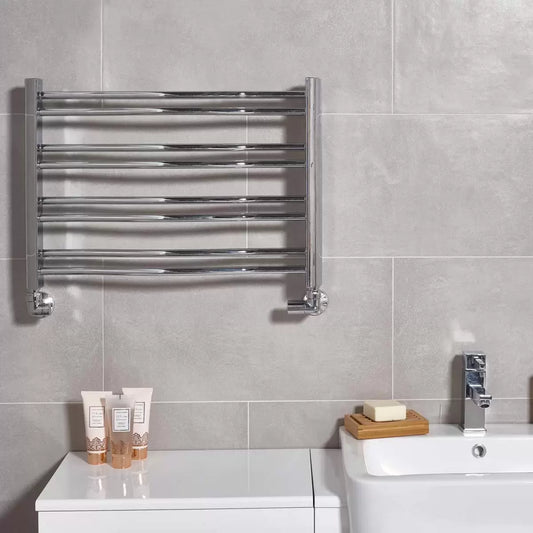 Front view of the Ultraheat Petit chrome radiator mounted on a neutral tiled en-suite wall, displaying eight polished horizontal towel rails.