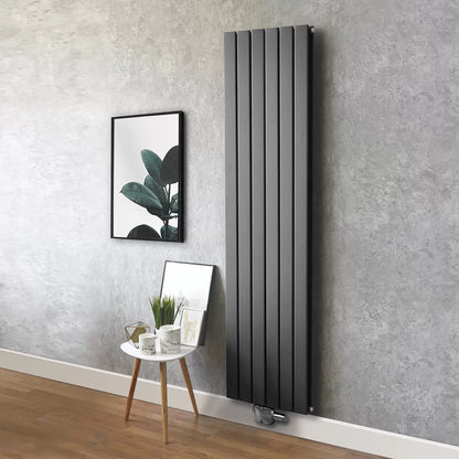 Vertical Ultraheat Tian Slate Grey tubular radiator mounted on a light gray wall in a modern open-plan living room setup.