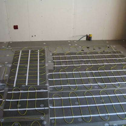 Varme 200W electric underfloor heating mat rolled out on concrete subfloor with included primer and roller.