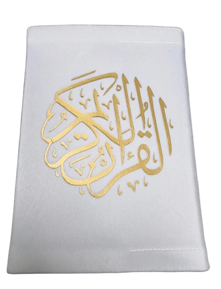 Angle view of a black soft velvet covered 13-line Quran with gold Arabic logo next to its matching velvet holder inside an open presentation gift box.