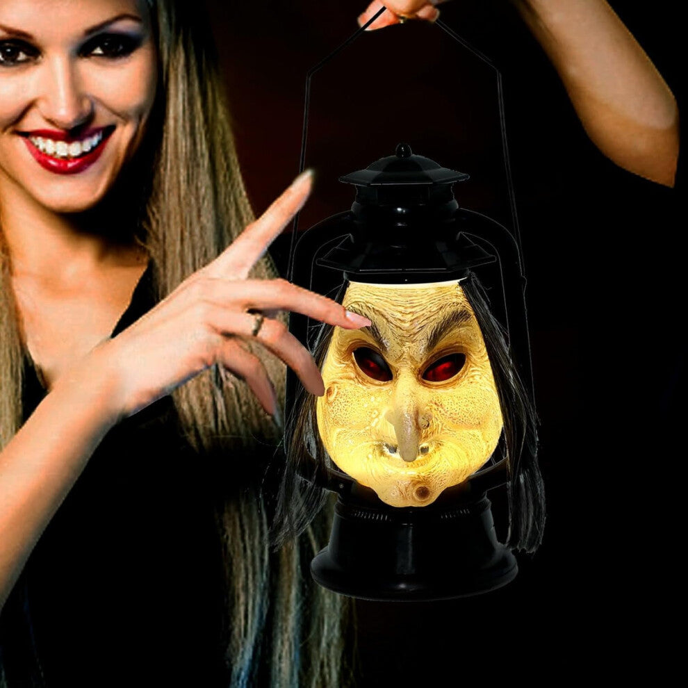 A handcrafted vintage Halloween long hair witch hanging decoration with LED lights and sound effects displayed in a spooky garden setting.