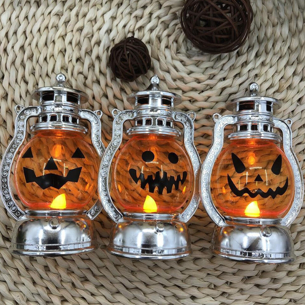 A vintage electroplated plastic electronic Halloween pumpkin lantern glowing softly on a decorative tabletop.