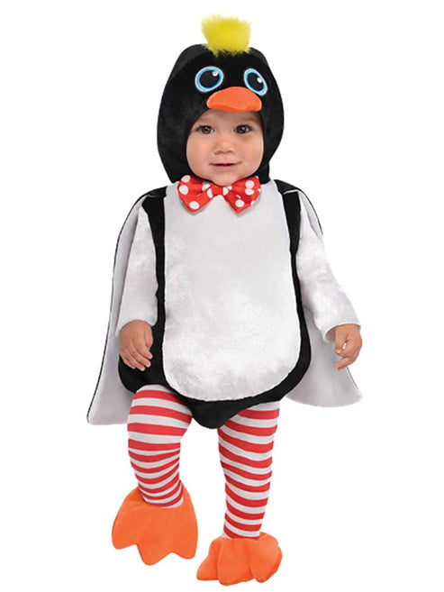 Front view of a toddler wearing the plush black and white Waddles the Penguin bodysuit with red bow-tie, yellow tufted hood, and striped tights in a bright studio setup.