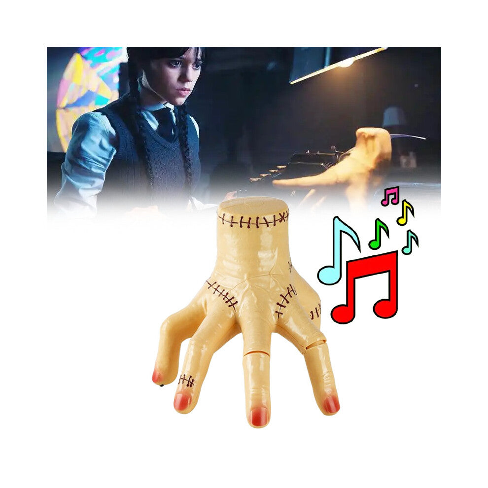 An animated Wednesday Addams Thing crawling hand prop featuring LED lights and spooky details positioned on a dark table.
