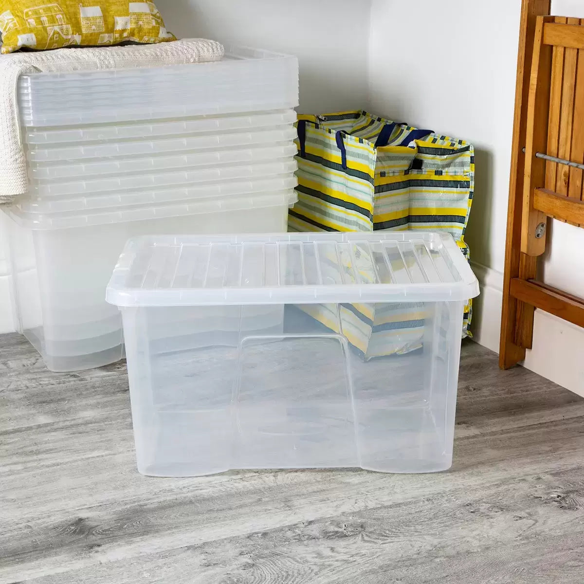 A stack of five transparent Wham 60-litre plastic storage boxes with securely clipped blue handles and lids, arranged neatly against a clean white workshop background.