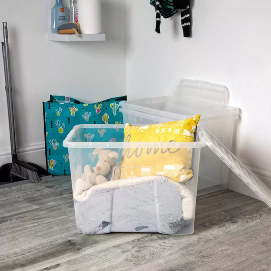 Three stacked Wham 80L crystal clear plastic storage boxes with matching snap-on lids arranged vertically in a bright, organized home utility room setting.