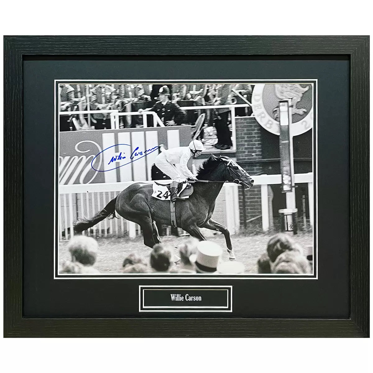 Willie Carson signed photograph in a black wooden frame mounted on a neutral interior wall background.