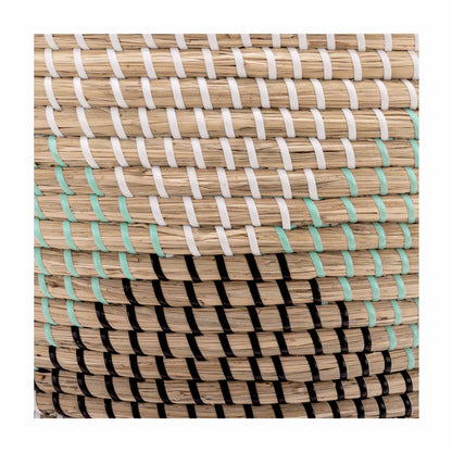 Pair of two nesting handwoven natural brown seagrass storage baskets with integrated handles arranged on a light wood floor in a brightly lit living room.